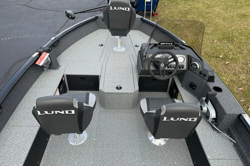 Slide: The Image of 2026 Lund 1800 Explorer SS boat interior with steering console and seating. - 8