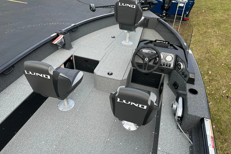 Slide: The Image of 2026 Lund 1800 Explorer SS boat interior with steering console and seating. - 9
