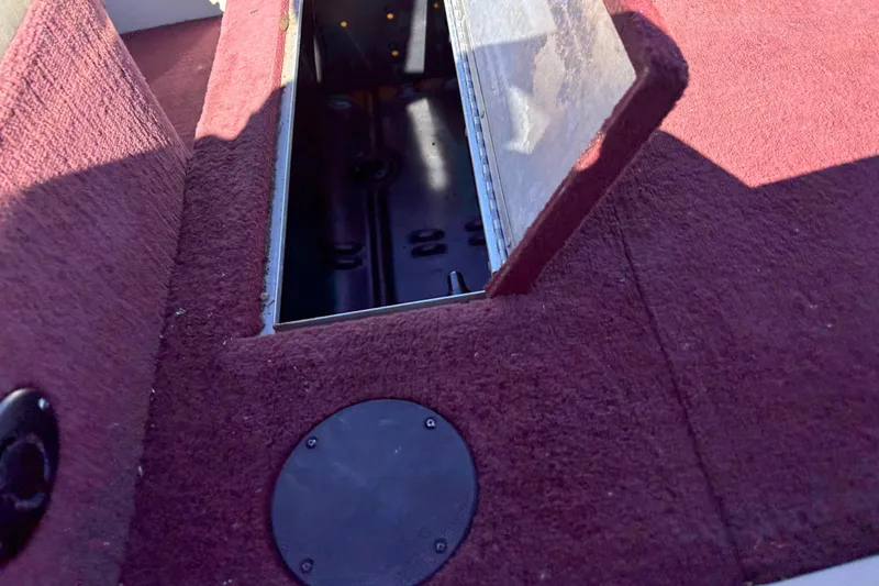 Slide: The Image of Open storage compartment on 2002 Sea Nymph FM 165 S boat with maroon carpet. - 12