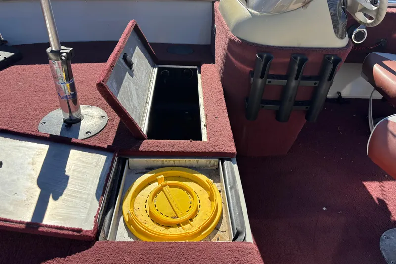 Slide: The Image of 2002 Sea Nymph FM 165 S boat interior with open storage compartments and rod holders. - 13