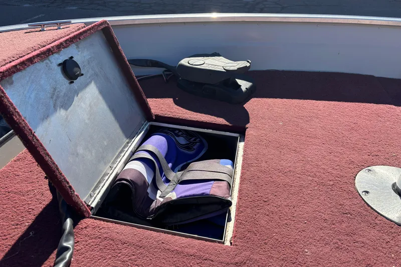 Slide: The Image of Open storage compartment on 2002 Sea Nymph FM 165 S boat with life jacket inside. - 14