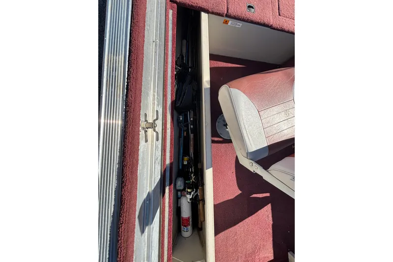 Slide: The Image of Storage compartment in a 2002 Sea Nymph FM 165 S boat with fishing gear and fire extinguisher. - 15