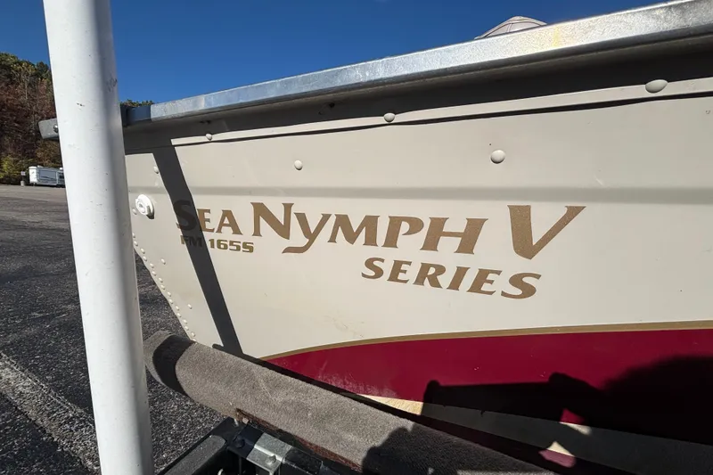 Slide: The Image of 2002 Sea Nymph FM 165 S boat, beige and red, parked on a trailer. - 3