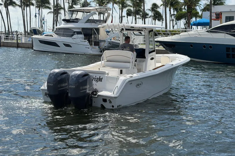 Slide: The Image of 2022 Sea Hunt Ultra 275 SE boat with dual Yamaha engines in a marina setting. - 10
