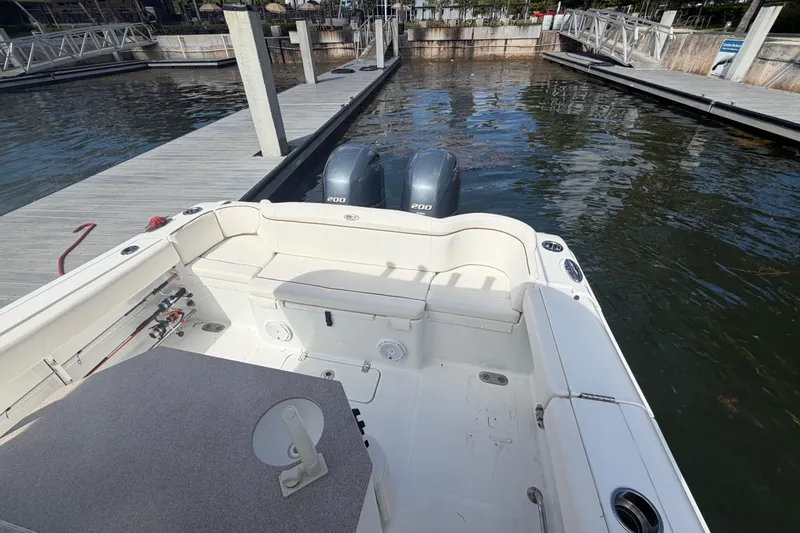 Slide: The Image of 2022 Sea Hunt Ultra 275 SE boat docked, featuring spacious seating and twin outboard engines. - 15