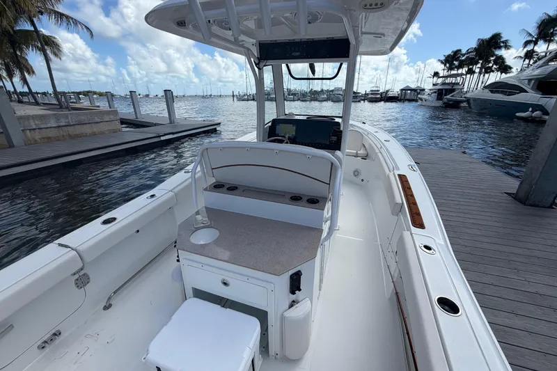 Slide: The Image of 2022 Sea Hunt Ultra 275 SE boat docked at marina, clear sky, calm water. - 22