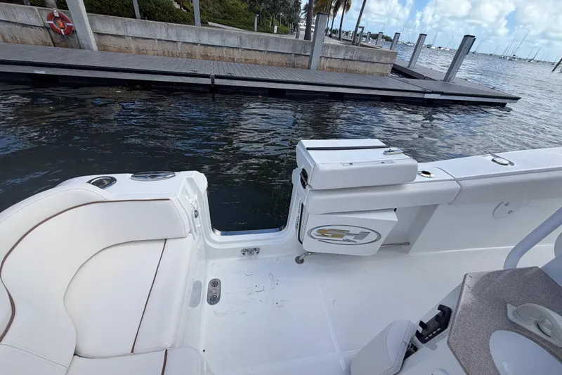 Slide: The Image of 2022 Sea Hunt Ultra 275 SE boat interior near dock, showcasing seating and water view. - 24