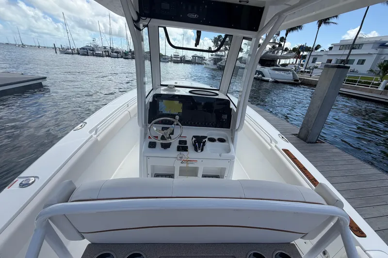 Slide: The Image of 2022 Sea Hunt Ultra 275 SE boat interior at marina, featuring helm and seating. - 26