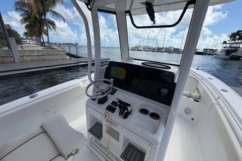 Slide: The Image of 2022 Sea Hunt Ultra 275 SE boat interior with steering console, docked by marina. - 27