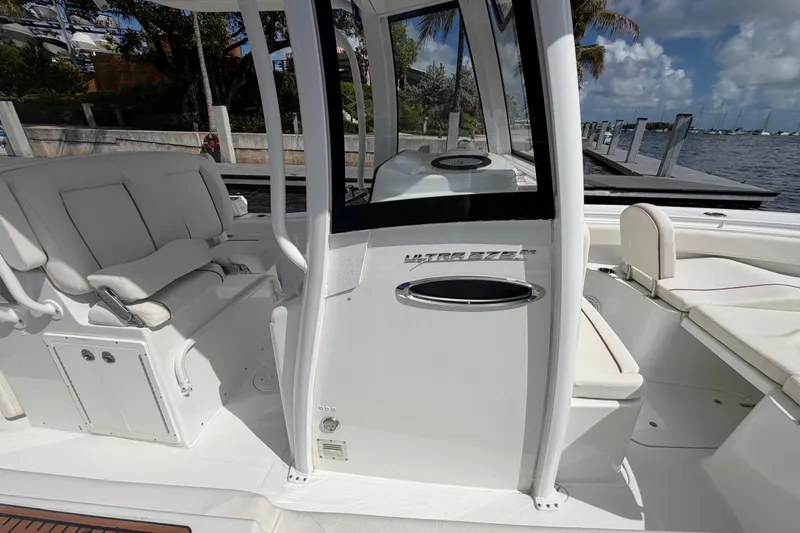 Slide: The Image of 2022 Sea Hunt Ultra 275 SE boat interior with seating and helm, docked by the water. - 35