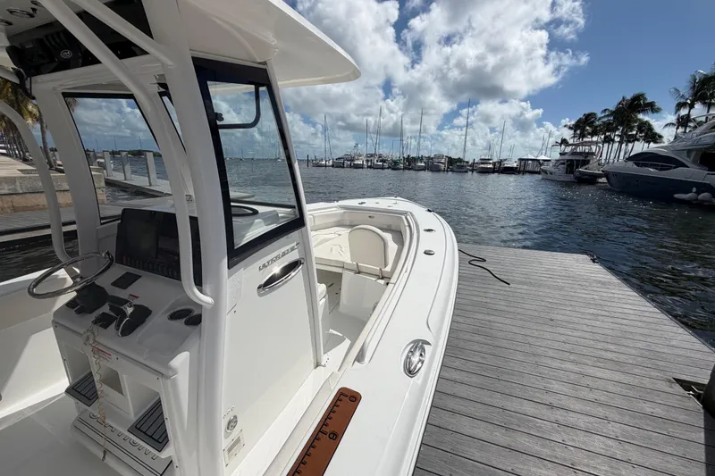 Slide: The Image of 2022 Sea Hunt Ultra 275 SE boat docked at marina under blue sky. - 40