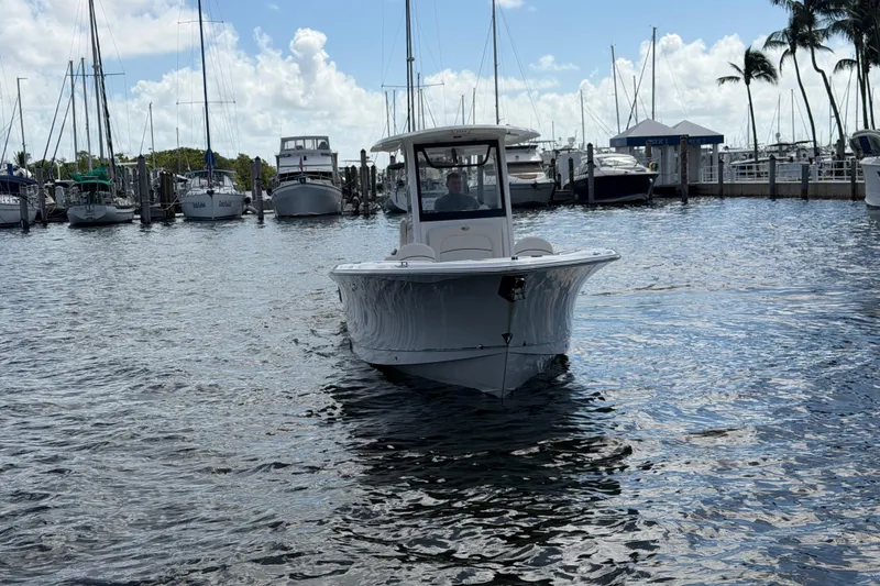 Slide: The Image of 2022 Sea Hunt Ultra 275 SE boat in a marina with sailboats and palm trees. - 7