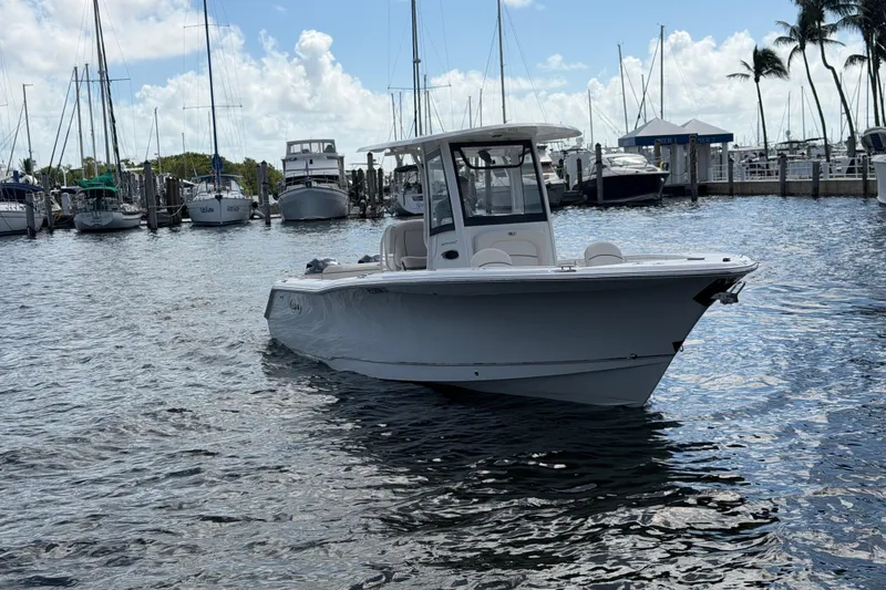 Slide: The Image of 2022 Sea Hunt Ultra 275 SE boat docked in a marina with sailboats. - 8