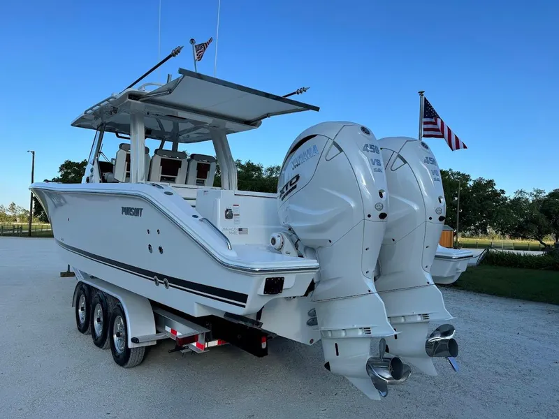 Slide: The Image of 2024 Pursuit S 358 Sport boat with dual engines on a trailer, American flag visible. - 11
