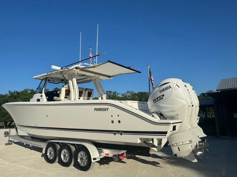 Slide: The Image of 2024 Pursuit S 358 Sport boat on trailer with Yamaha engines, parked outdoors. - 16