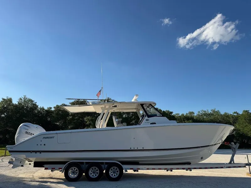 Slide: The Image of 2024 Pursuit S 358 Sport boat on trailer under clear blue sky. - 2