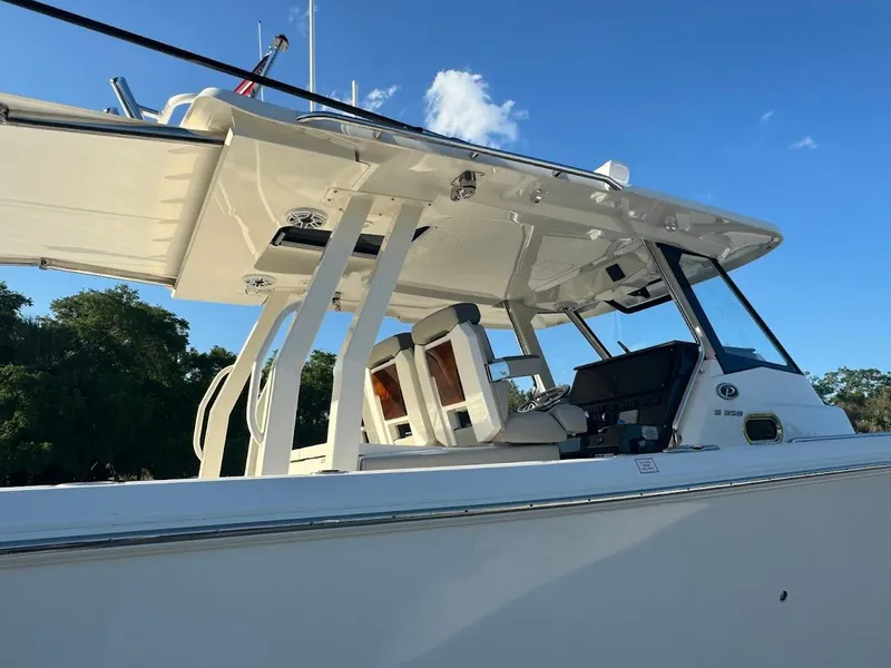 Slide: The Image of 2024 Pursuit S 358 Sport boat, sleek design, white exterior, clear blue sky background. - 30