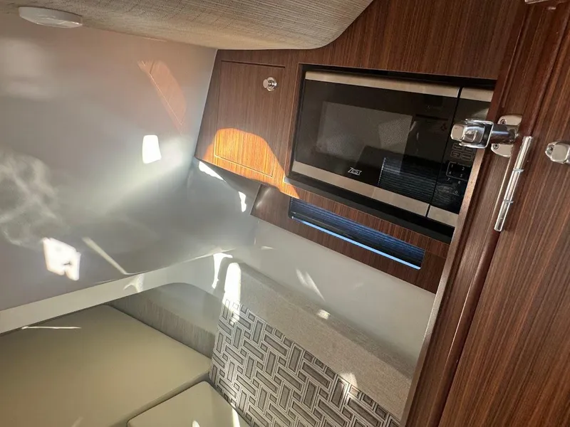 Slide: The Image of 2024 Pursuit S 358 Sport cabin interior with microwave and modern wood finish. - 37