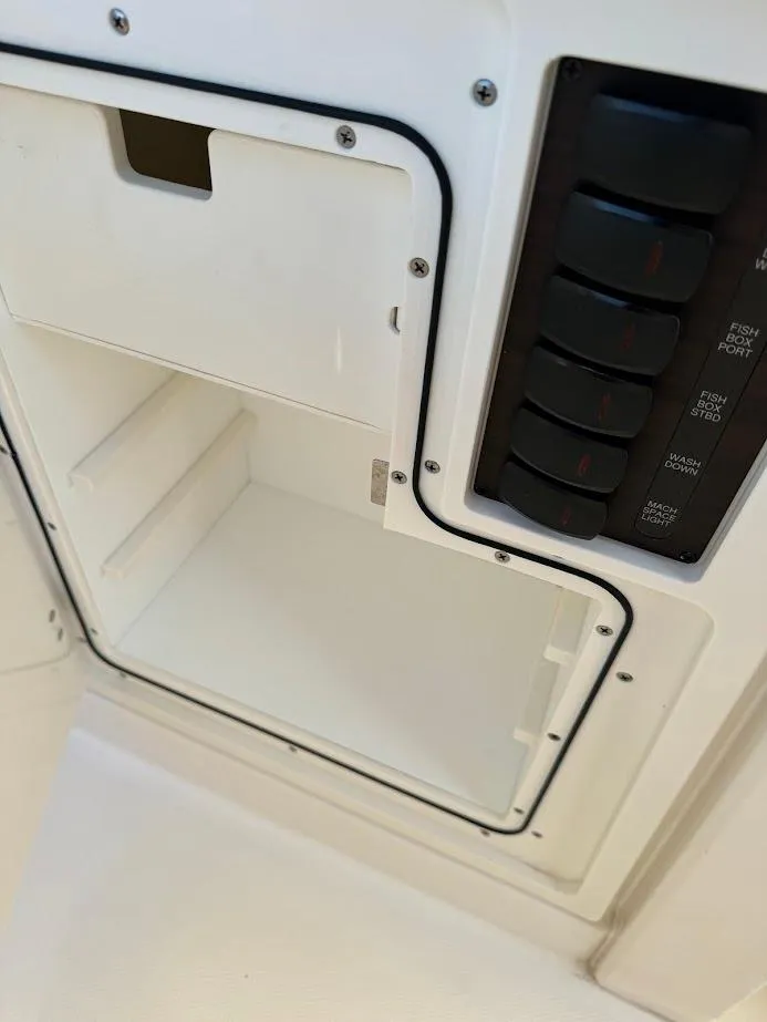 Slide: The Image of 2024 Pursuit S 358 Sport boat compartment with control panel and storage space. - 47