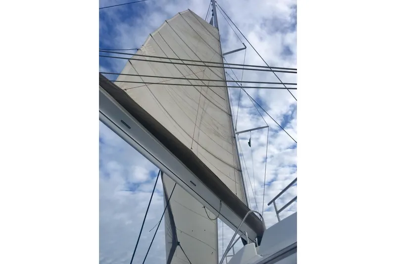 Slide: The Image of Sailing yacht FONTAINE PAJOT 63, 2014 model, with sails unfurled against a cloudy sky. - 16