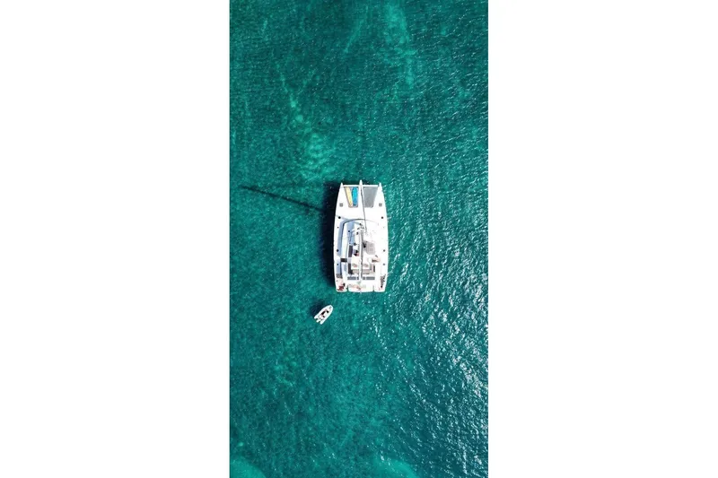 Slide: The Image of Aerial view of 2014 FONTAINE PAJOT 63 catamaran on clear turquoise water. - 2