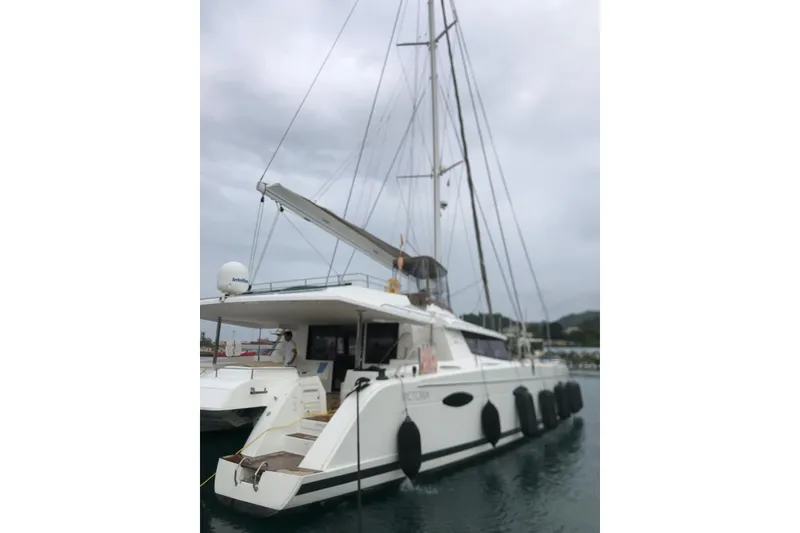 Slide: The Image of 2014 FONTAINE PAJOT 63 catamaran docked in a marina under cloudy skies. - 20