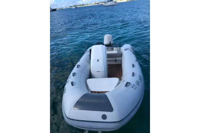 Slide: The Image of Inflatable boat on water, 2014 FONTAINE PAJOT 63 model, with distant yachts in background. - 26