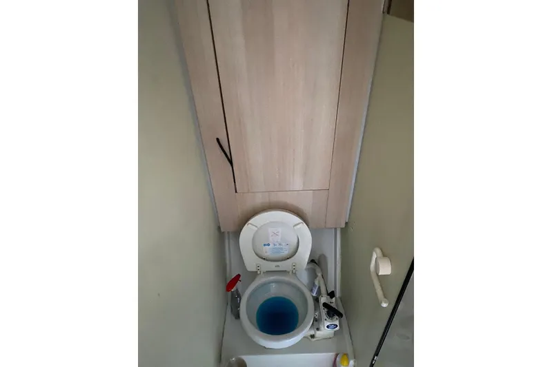 Slide: The Image of Toilet area in 2014 FONTAINE PAJOT 63 yacht, featuring blue water and wooden cabinet. - 41
