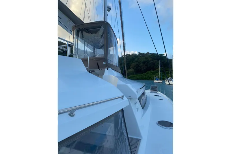 Slide: The Image of 2014 FONTAINE PAJOT 63 yacht on calm water with lush green backdrop. - 48