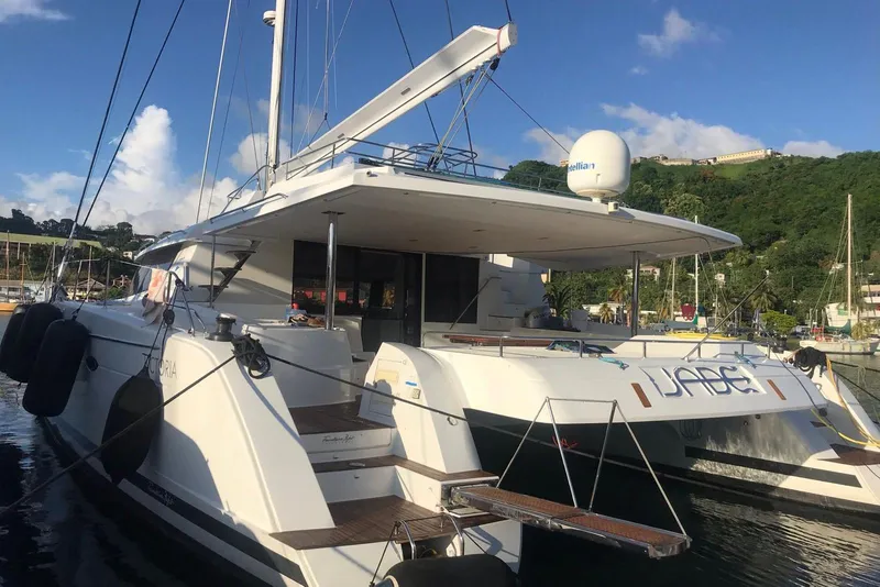 Slide: The Image of 2014 FONTAINE PAJOT 63 catamaran docked in a scenic marina setting. - 5