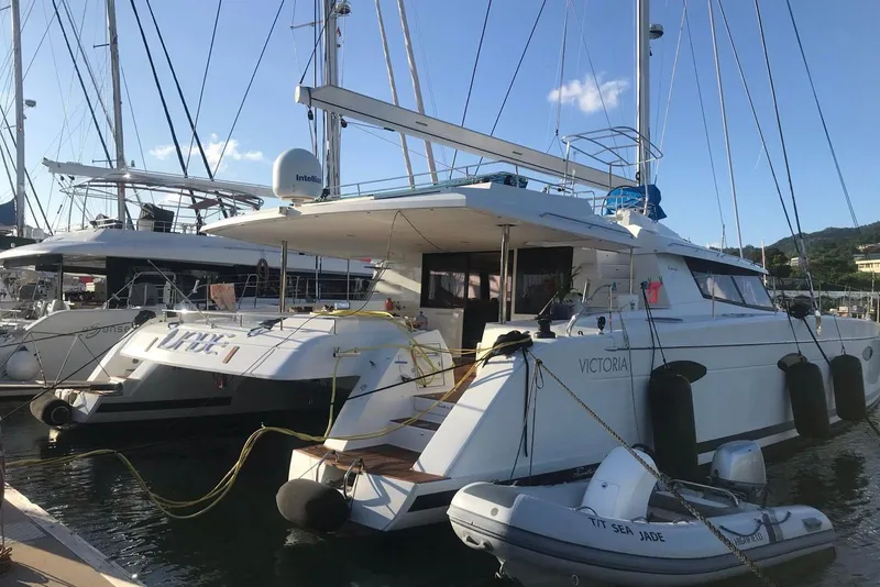 Slide: The Image of 2014 FONTAINE PAJOT 63 yacht docked at marina with inflatable boat nearby. - 6