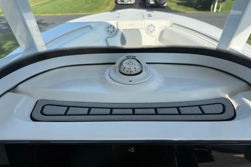 Slide: The Image of 2019 Tidewater 232 CC Adventure boat dashboard with compass and control panel. - 14