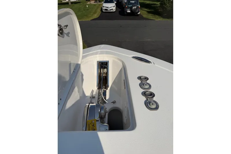Slide: The Image of 2019 Tidewater 232 CC Adventure boat anchor compartment with open lid, showcasing anchor mechanism. - 17