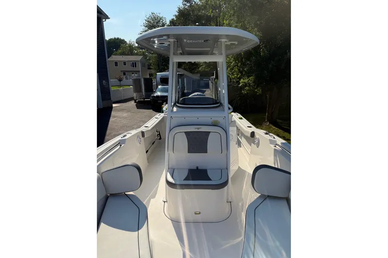 Slide: The Image of 2019 Tidewater 232 CC Adventure boat with T-top and seating, parked outdoors. - 7