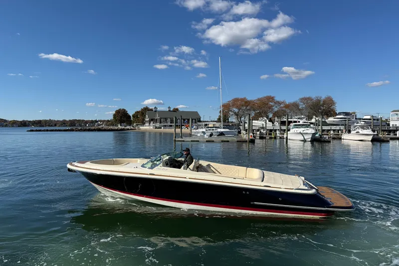 The Image of 2018 Chris-Craft Launch 30 boat cruising on a sunny day near a marina. - 0