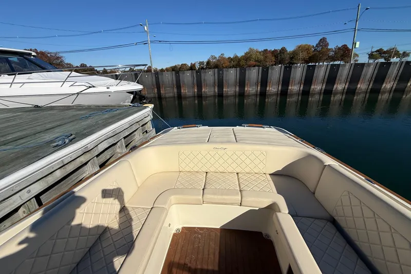 Slide: The Image of 2018 Chris-Craft Launch 30 boat with beige seating, docked by a wooden pier. - 16