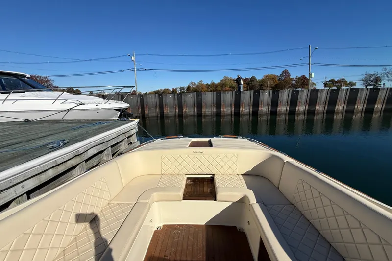 Slide: The Image of 2018 Chris-Craft Launch 30 boat interior with beige seating, docked by calm water. - 17