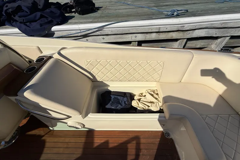 Slide: The Image of 2018 Chris-Craft Launch 30 boat interior with beige quilted seating and storage compartment. - 20