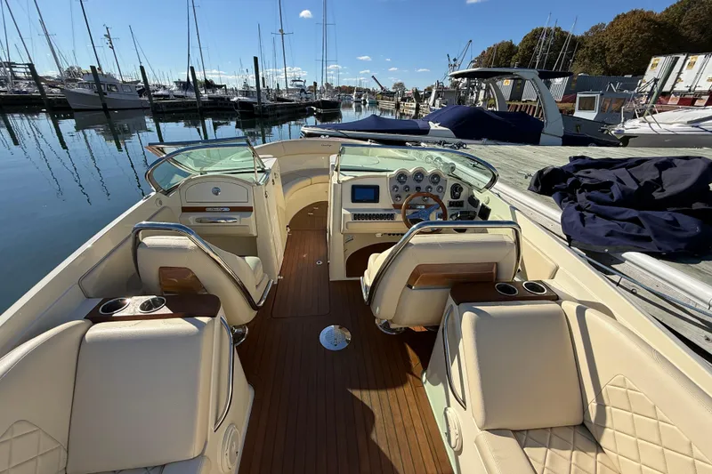 Slide: The Image of 2018 Chris-Craft Launch 30 boat interior with luxurious seating and dashboard, docked at marina. - 24