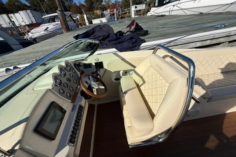 Slide: The Image of 2018 Chris-Craft Launch 30 boat interior with beige seating and dashboard controls. - 29