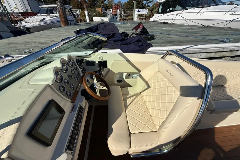 Slide: The Image of 2018 Chris-Craft Launch 30 boat interior with beige leather seats and dashboard controls. - 30