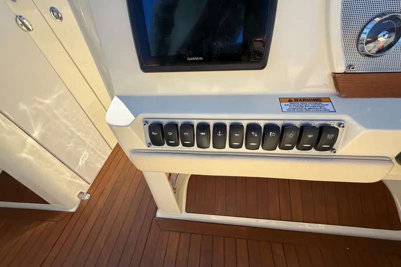 Slide: The Image of Control panel of a 2018 Chris-Craft Launch 30 boat with switches and a Garmin display. - 35