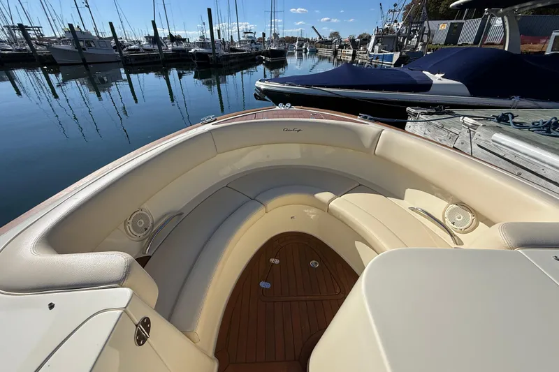 Slide: The Image of 2018 Chris-Craft Launch 30 boat interior with beige seating at a marina. - 41