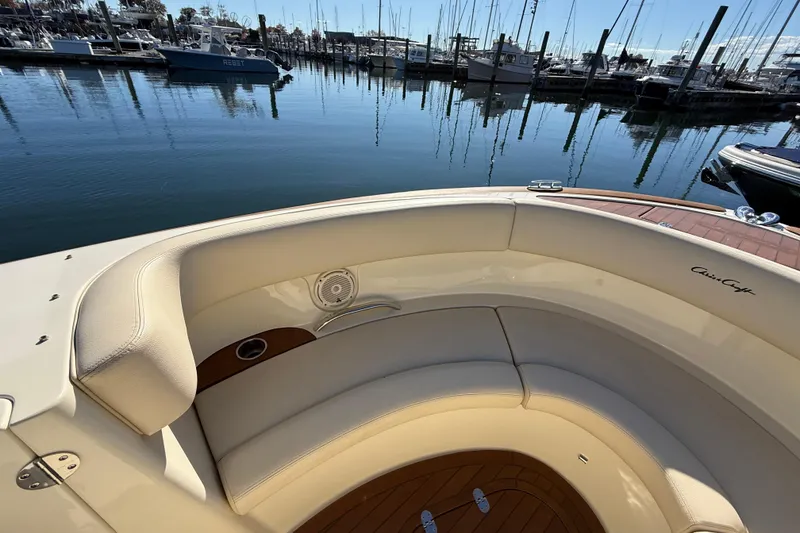 Slide: The Image of 2018 Chris-Craft Launch 30 boat interior with cream seating, docked at a marina. - 42