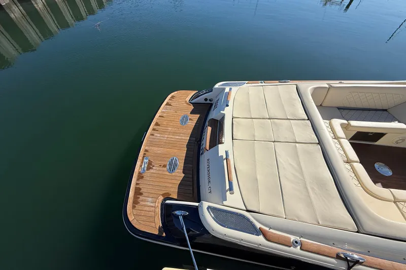 Slide: The Image of 2018 Chris-Craft Launch 30 boat with teak deck and cream upholstery, docked on calm water. - 5