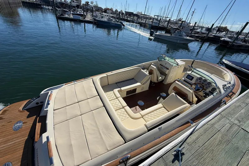 Slide: The Image of 2018 Chris-Craft Launch 30 boat docked at marina, featuring luxurious seating and elegant design. - 6
