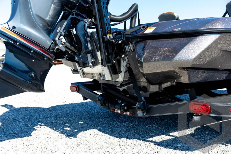 Slide: The Image of 2026 Skeeter ZXE20 boat engine and trailer detail on gravel surface. - 20