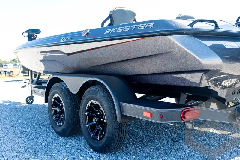 Slide: The Image of 2026 Skeeter ZXE20 boat on trailer, showcasing sleek design and dual-axle wheels. - 27