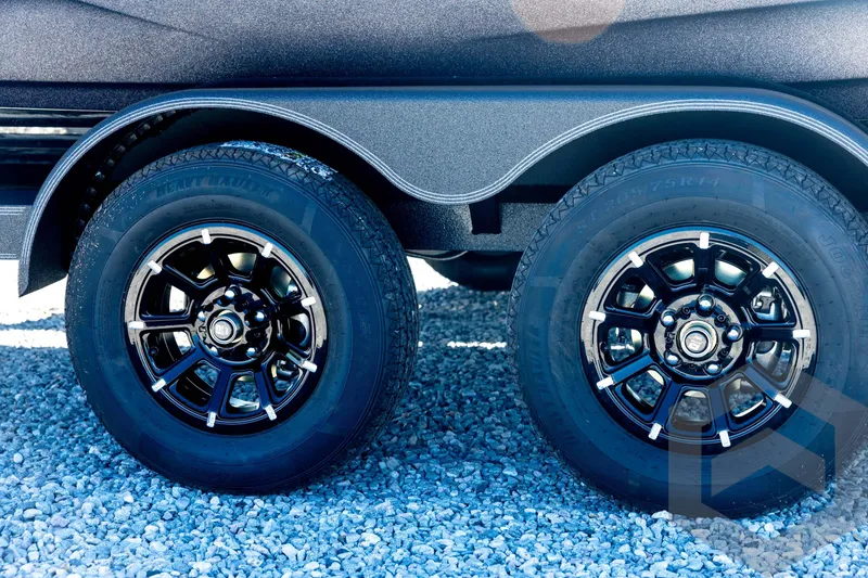 Slide: The Image of 2026 Skeeter ZXE20 trailer wheels on gravel surface, featuring sleek black rims. - 32