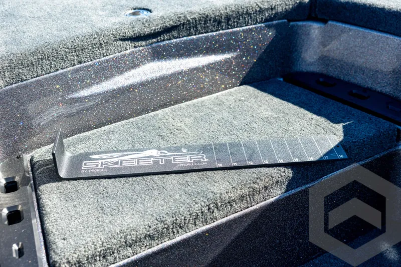 Slide: The Image of 2026 Skeeter ZXE20 boat interior with measuring tool on carpeted surface. - 59